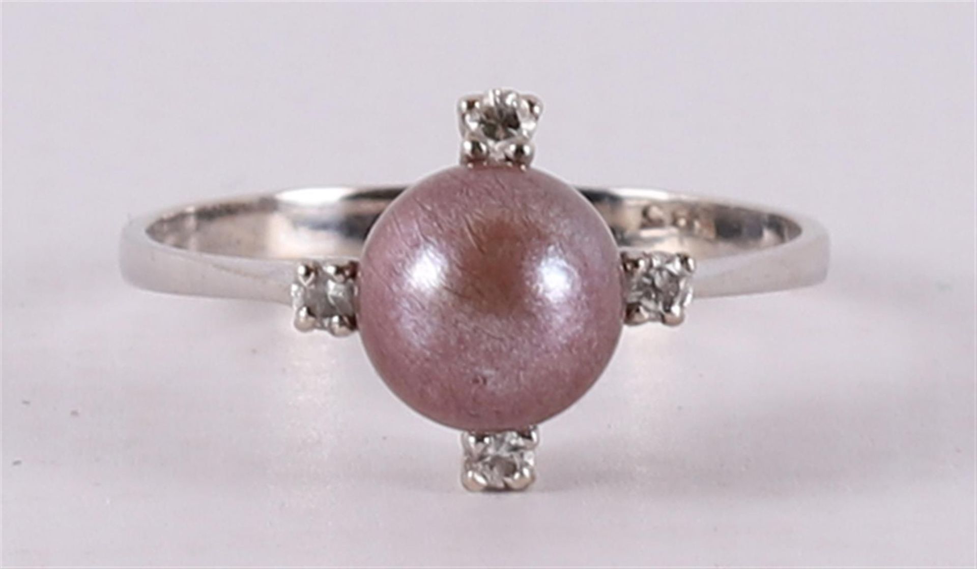 A 14 kt white gold women's ring, set with a pearl and four diamonds