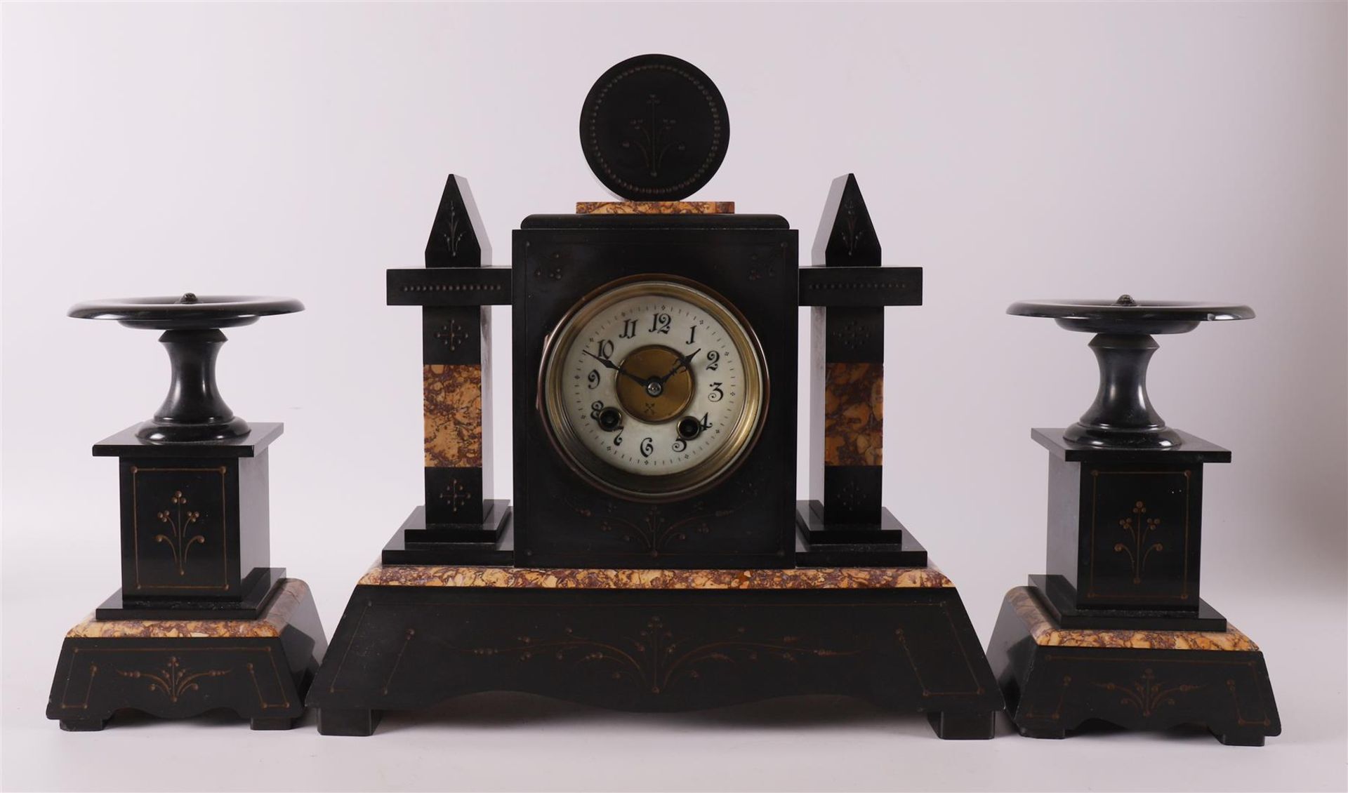 A three-piece black marble mantel clock, late 19th century.