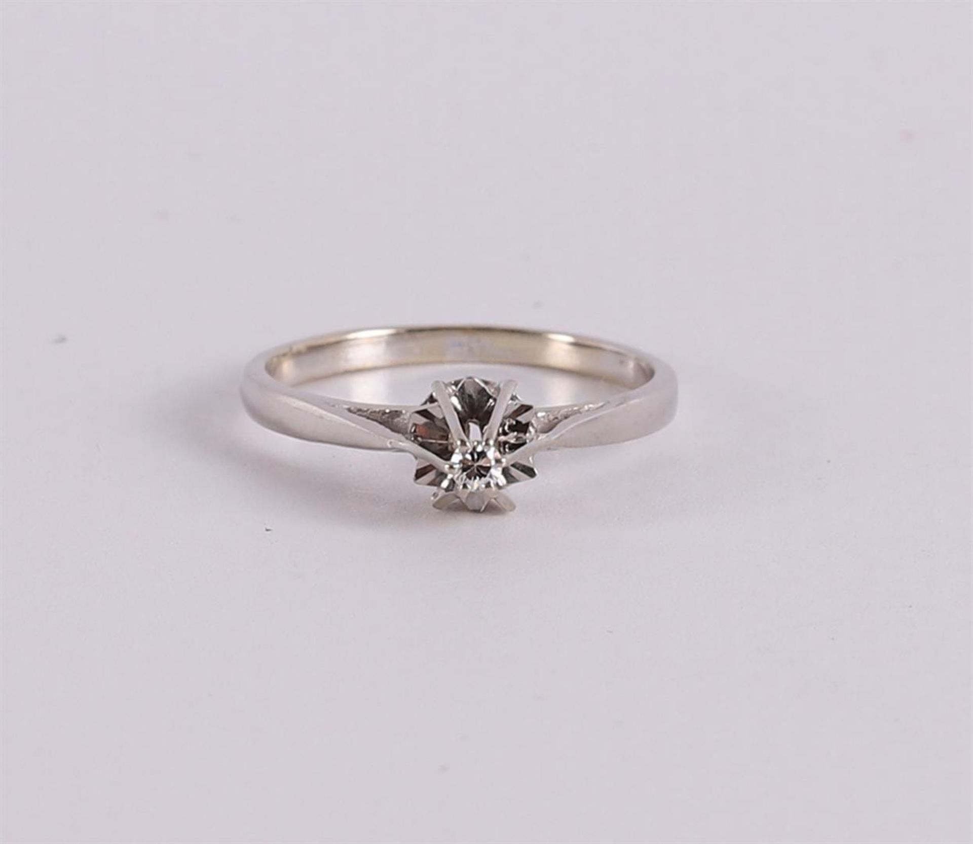 An 18 kt gold solitaire ring with a brilliant cut diamond.