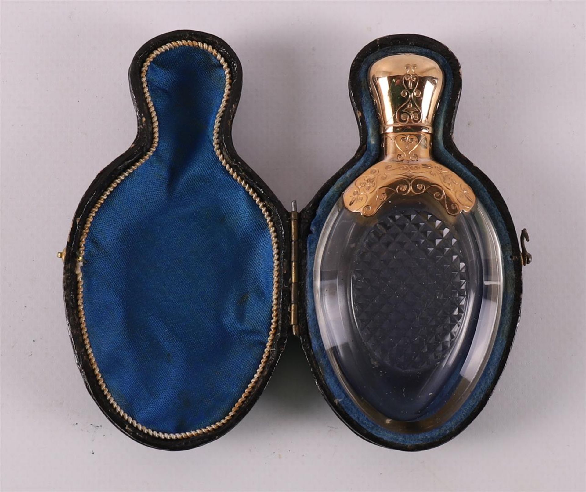 A clear crystal odor flask with gold lid and frame, around 1900