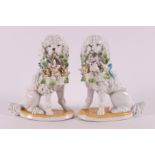 A pair of porcelain basket carrying poodles, 20th century