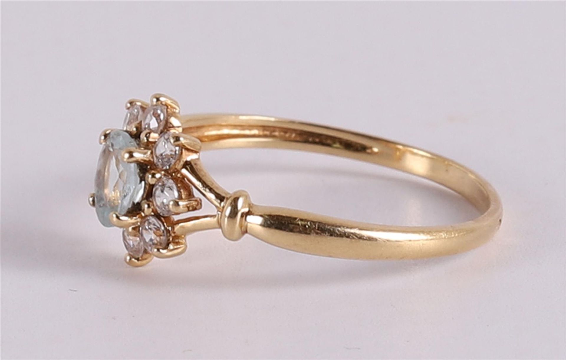 An 18 kt gold entourage ring with an oval aquamarine and zirconias. - Image 2 of 2