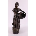A brown patinated white metal 'samac' woman with basket, France around 1900.