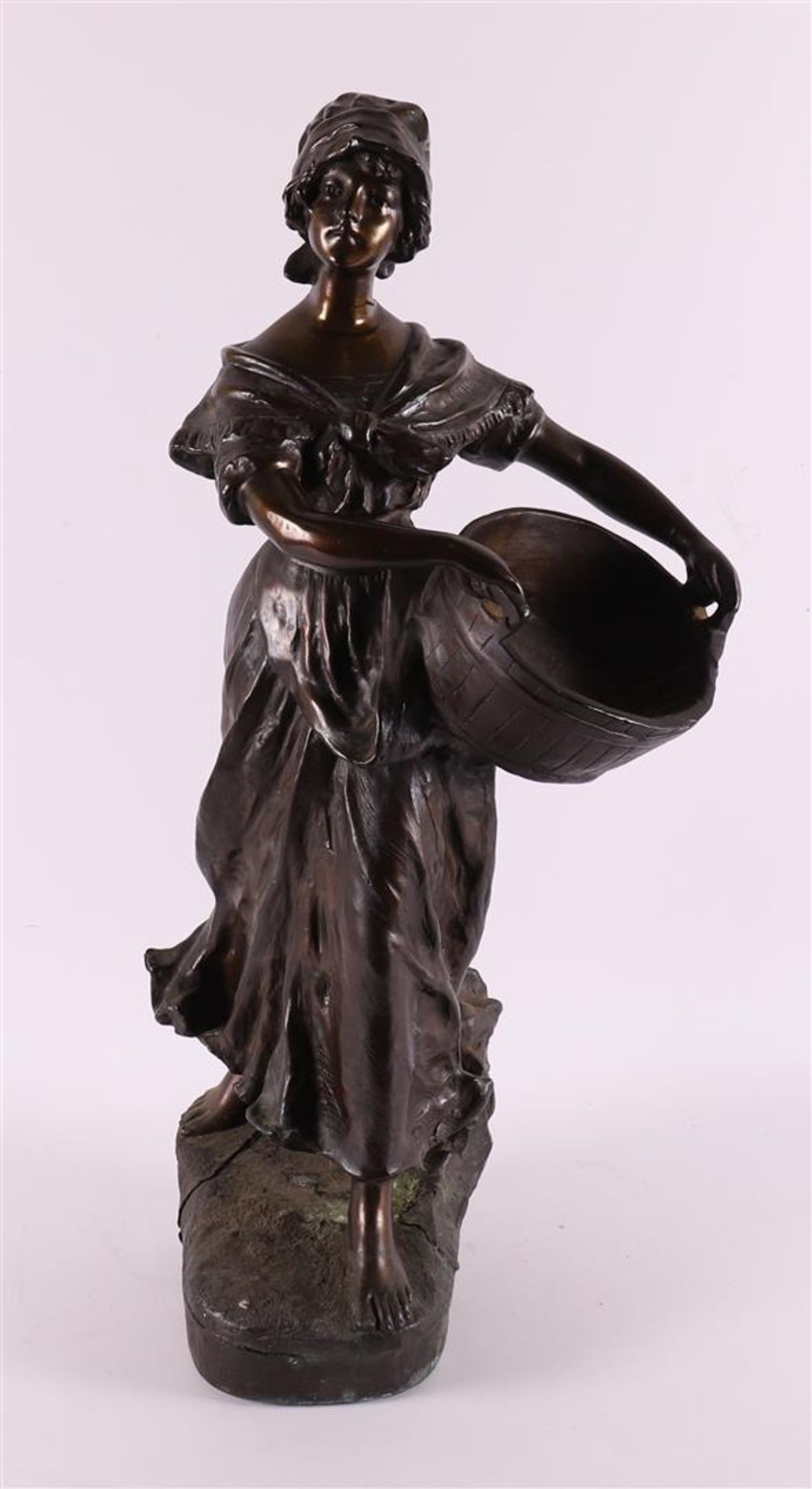 A brown patinated white metal 'samac' woman with basket, France around 1900.