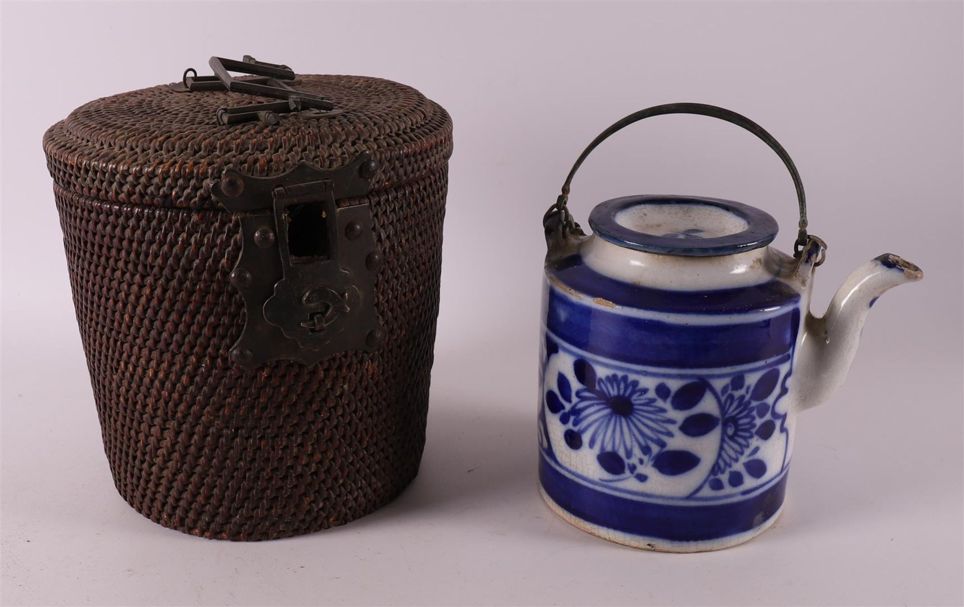 A blue/white porcelain teapot in a wicker case, China, around 1900.