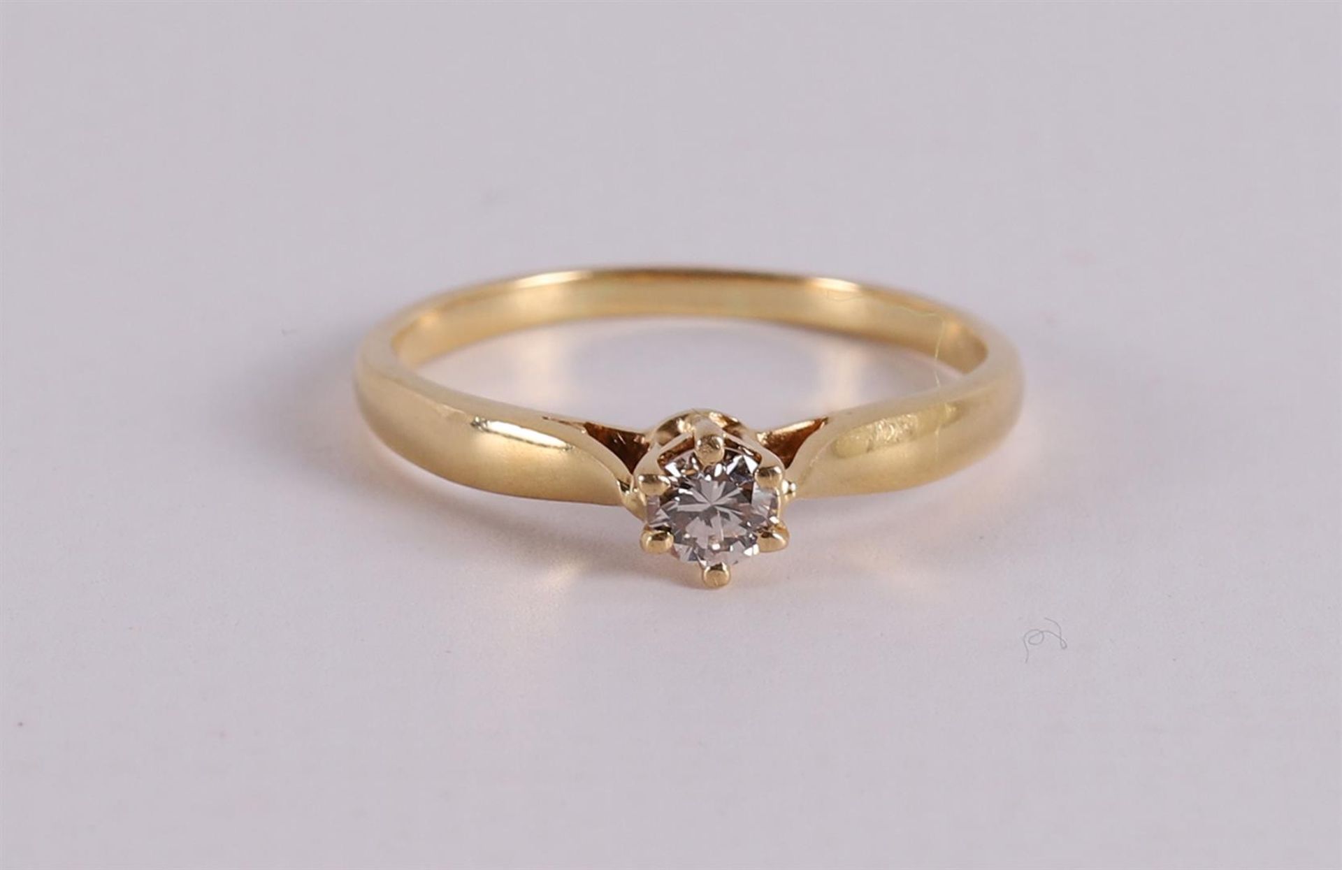 An 18 kt gold solitaire ring with a brilliant .