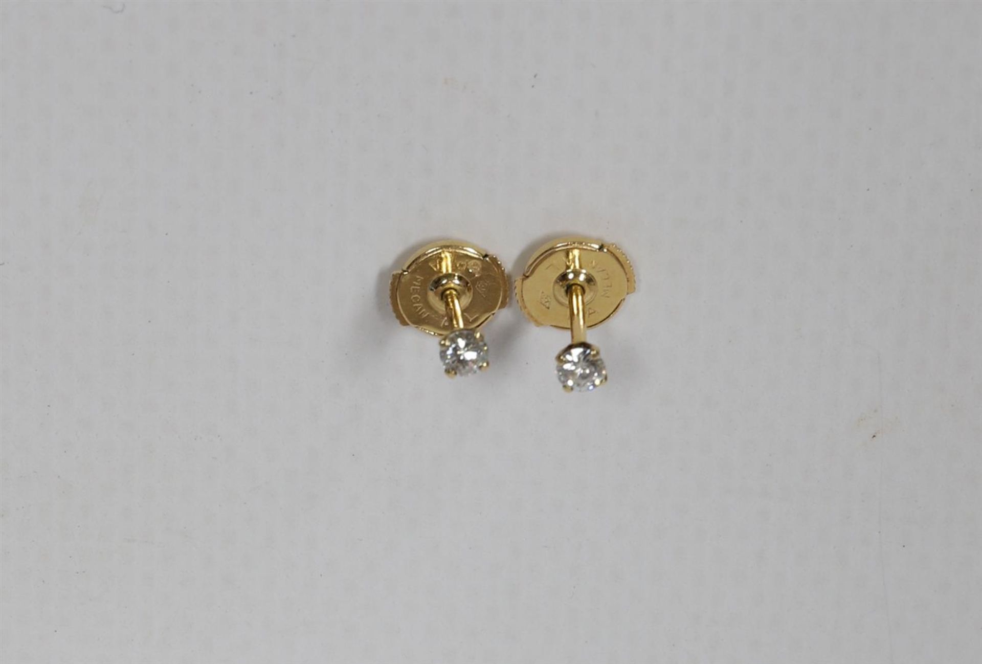 A pair of 18 kt gold stud earrings with 2 brilliant cut diamonds.