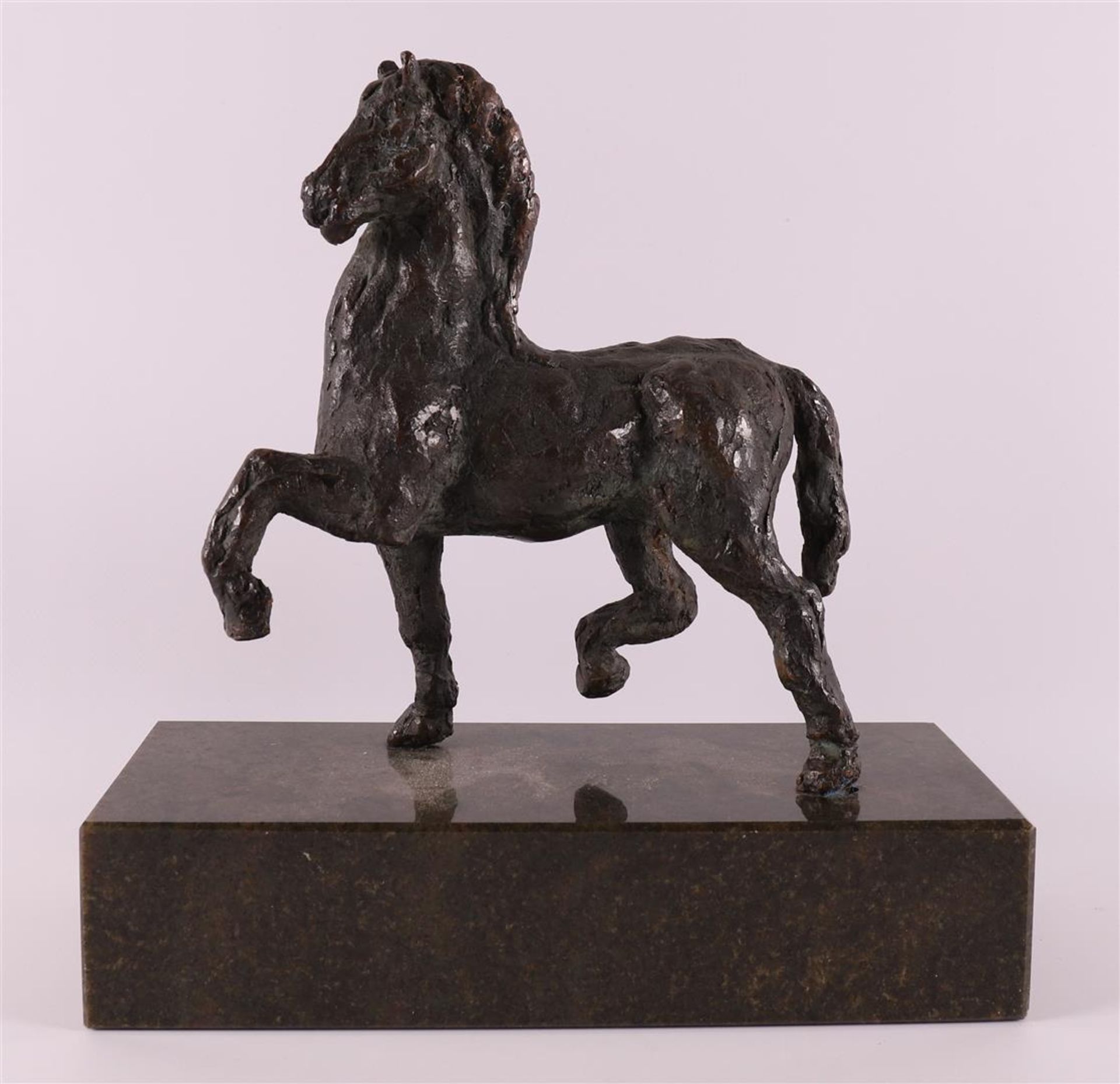 A brown patinated bronze horse on green natural stone base, 20th century.