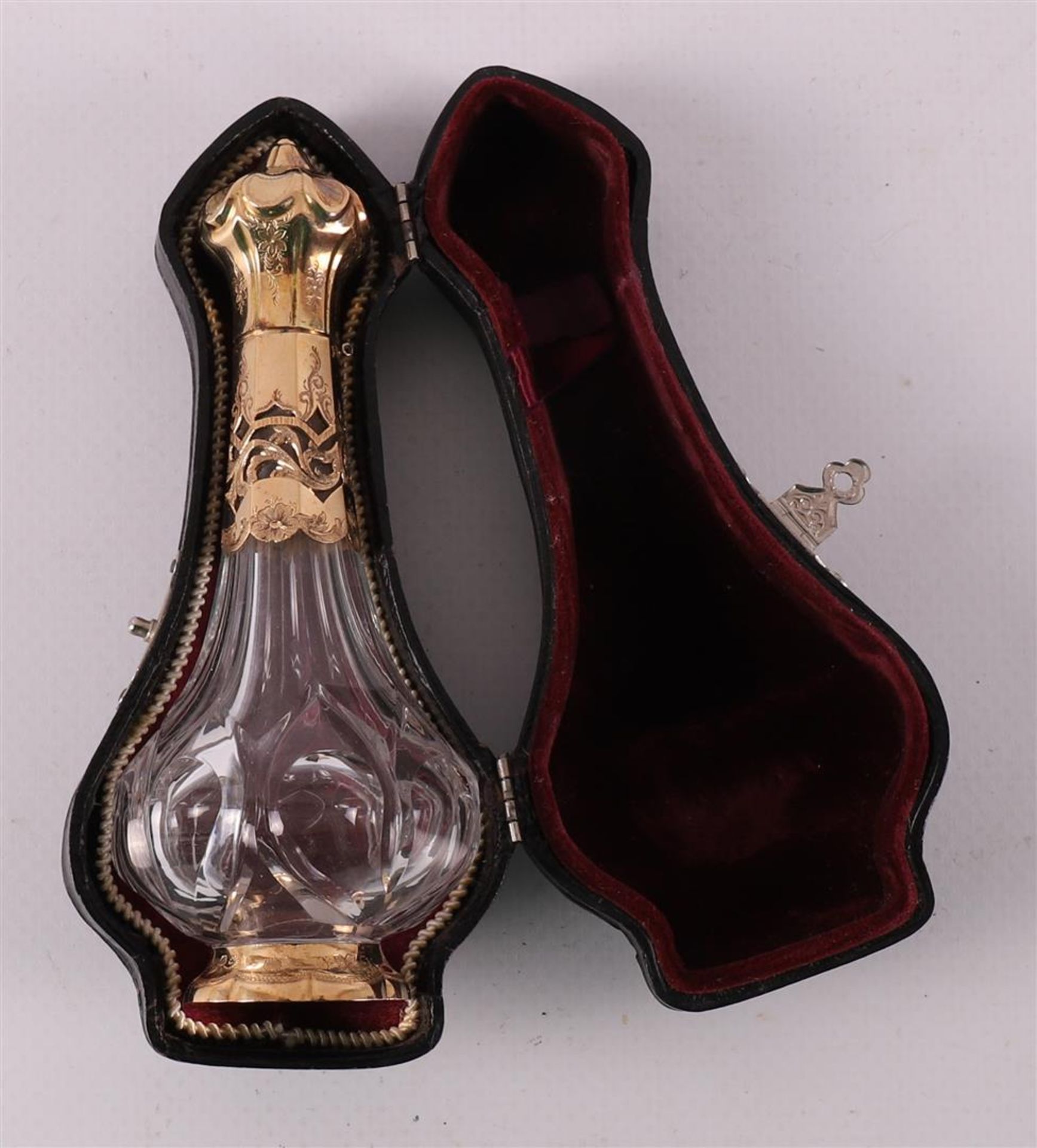 A clear crystal odor flask with gold lid and frame, 19th century.