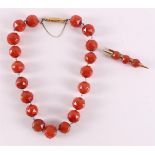 A faceted spherical carnelian necklace with a 14 kt gold clasp.