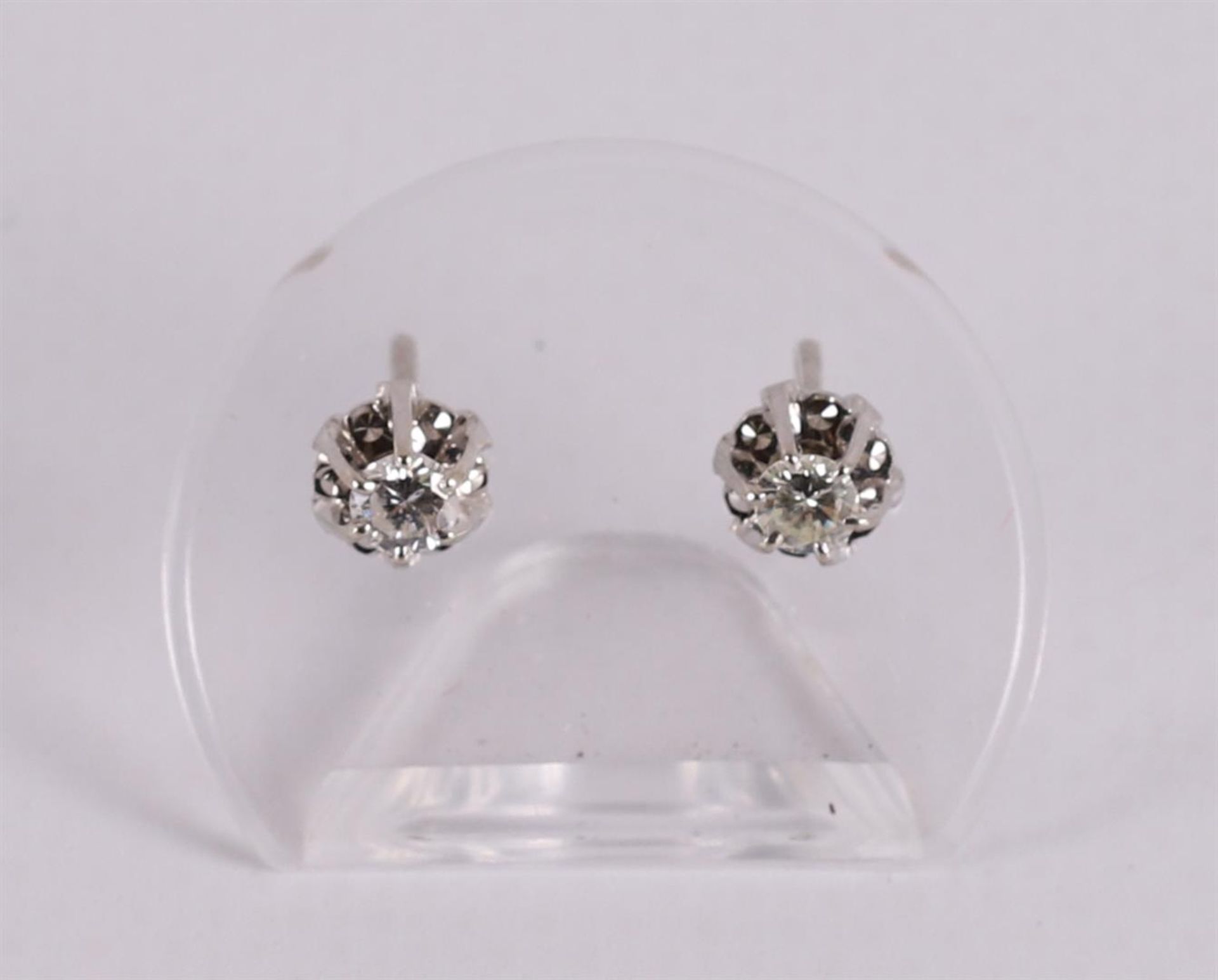 A pair of 14 kt gold stud earrings with 2 brilliant cut diamonds.