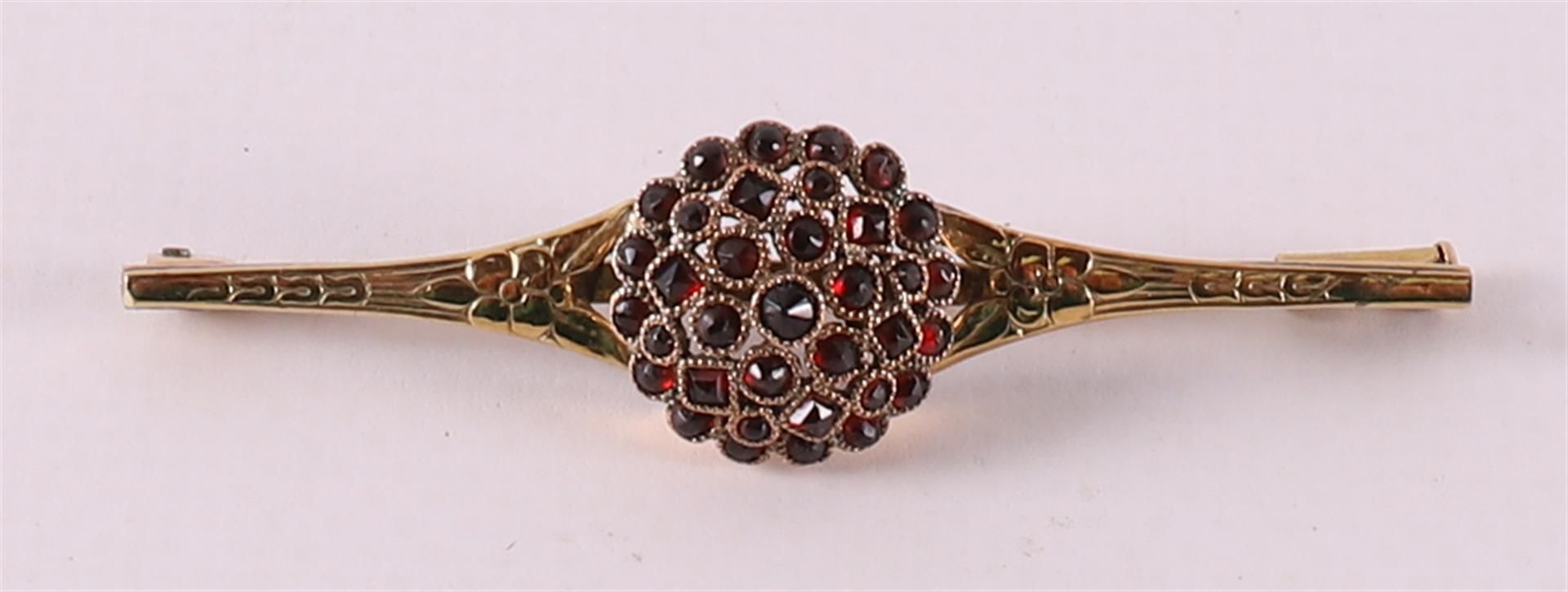 A 14 carat gold brooch set with many faceted garnets, around 1900.