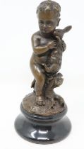 20th century cast bronze figure of a satyr clutching a hare raised on a black marble socle,