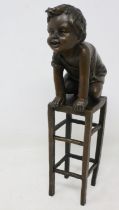 Bronze sculpture of a child kneeling on a chair, signed J. Clara, H: 24 cm. UK P&P Group 2 (£20+