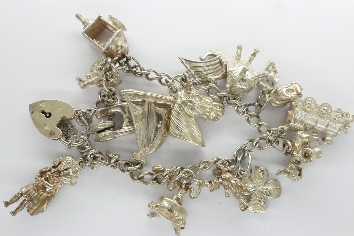 Silver charm bracelet with padlock clasp and fourteen charms, L: 18 cm. UK P&P Group 0 (£6+VAT for