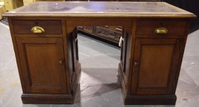 A Victorian oak twin pedestal partners desk, each side fitted with drawers and cupboards, with later