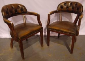 A pair of 20th century brown leather Chesterfield desk chairs.