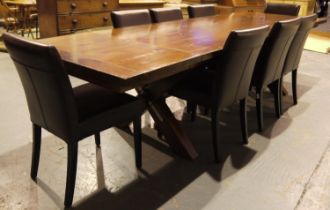 A substantial hardwood dining table, the extending top with two additional leaves raised on a