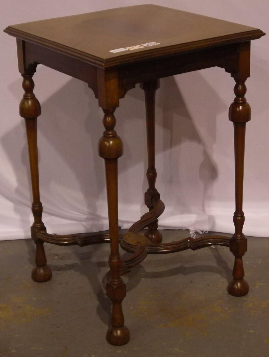 A 19th century inlaid lamp table with bent stretchers on turned supports with shaped stretchers,