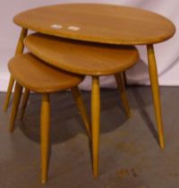 Ercol nest of three elm Pebble tables, largest 65 x 45 x 40 cm H. Smallest with repaired leg.