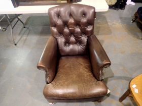 Modern aged brown leather fire sized armchair with buttoned back.