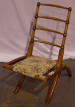 An Edwardian elm framed campaign chair, folding, with later upholstered seat, folding is secure