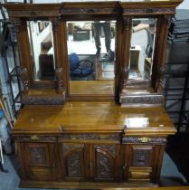 A substantial Victorian walnut sideboard with monumental upstand and mirrored back, carved facia's