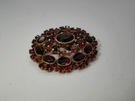 8ct gold garnet set oval brooch, L: 35 mm, 7.0g. UK P&P Group 0 (£6+VAT for the first lot and £1+VAT