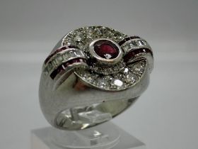 20th century unmarked white gold signet ring set with a large central ruby flanked and surrounded by