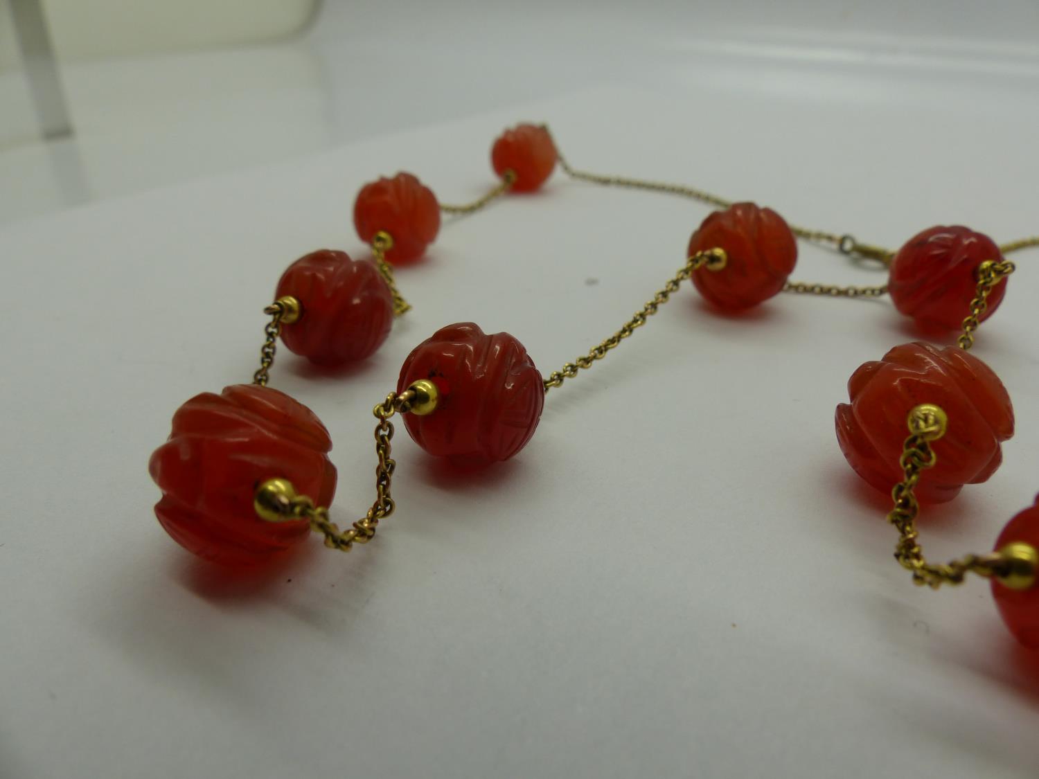 Unusual 19th century unmarked gold necklace, set with eleven carved carnelian beads, L: 63 cm. UK - Image 2 of 2