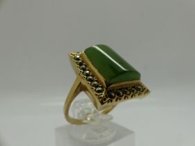 Unmarked 9ct gold ring set with large panel of jade surrounded by marcasite, size P/Q, 6.3g. UK P&