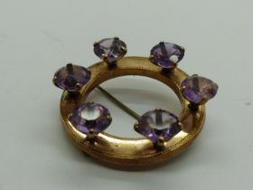 Unmarked gold brooch set with with six large amethysts, lacking pin catch, D: 42 mm, 11.7g. UK P&P