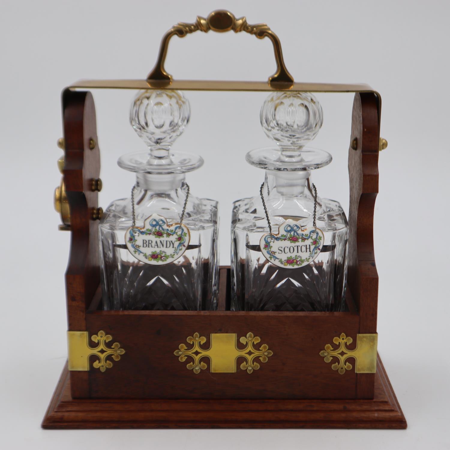 Two decanter locking tantalus (H: 28 cm)with solid mahogany frame, brass fittings and two associated