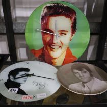 Two glass portrait clocks of Elvis with a further Elvis wall mounted plate, largest D: 35 cm. UK P&P