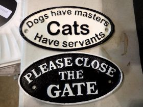 Two cast iron signs, Dogs Have Masters, Cats Have Servants, and Please Close The Gate, largest L: 20