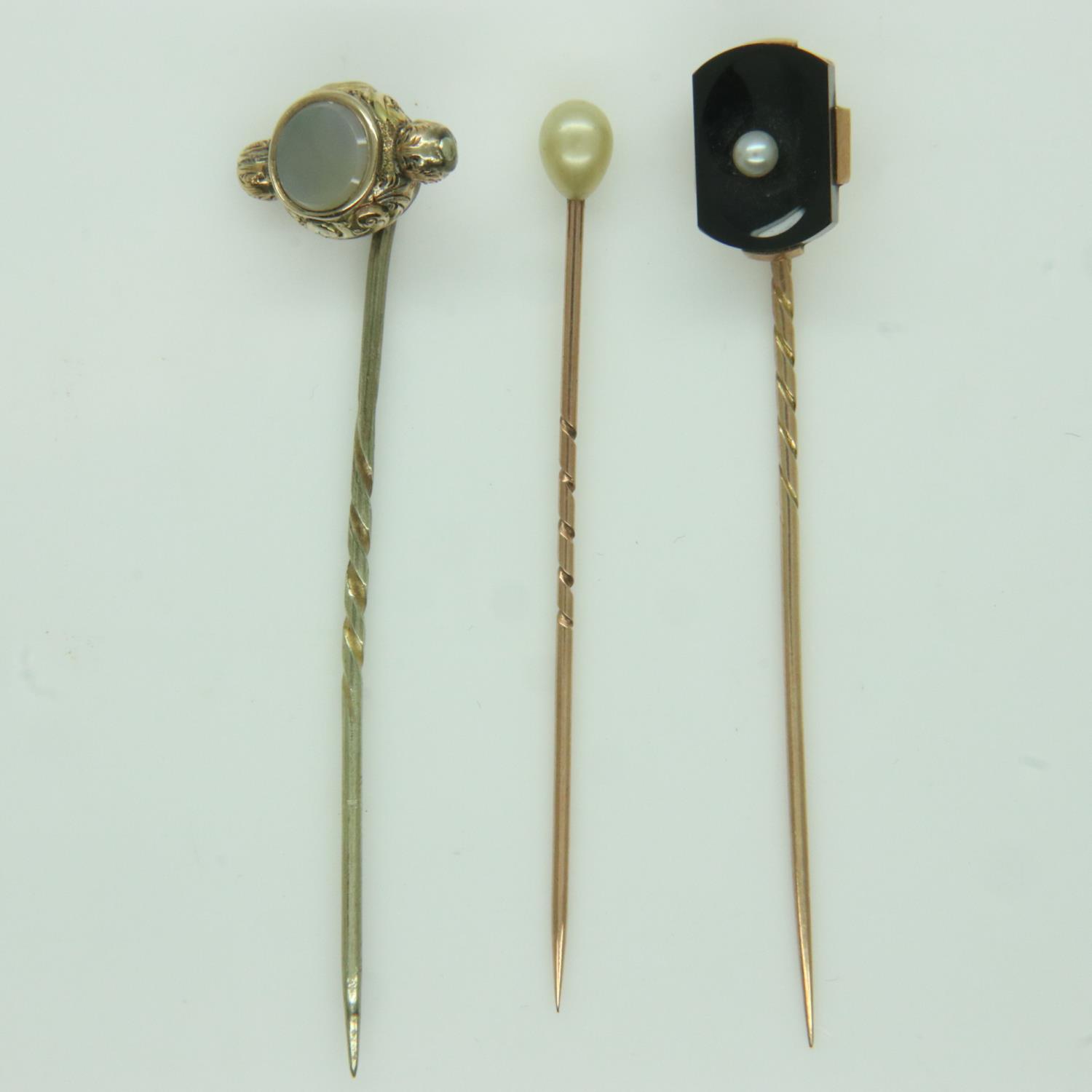 Three antique gold stick pins, set with pearl, onyx and chalcedony, 5.3g. UK P&P Group 0 (£6+VAT for