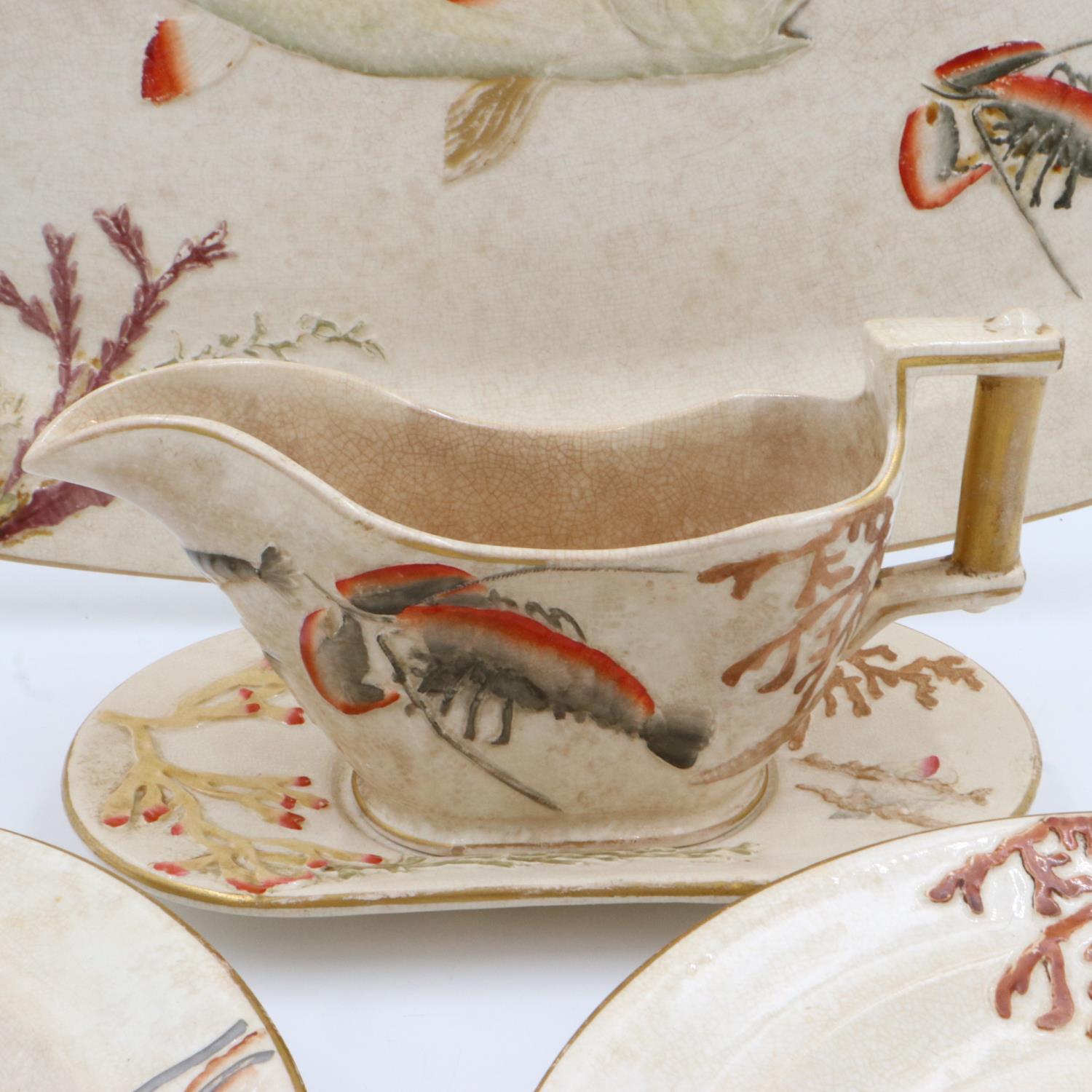 Nine relief moulded fish plates, one platter and one sauce bowl with stand, crazing and some cracks, - Image 2 of 4