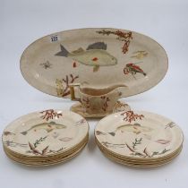 Nine relief moulded fish plates, one platter and one sauce bowl with stand, crazing and some cracks,