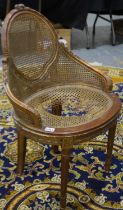 An early 20th century French boudoir chair, with bergere seat and backrest, for restoration. Not