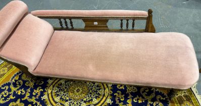 A Victorian chaise lounge, having a carved and moulded oak frame, turned supports terminating in