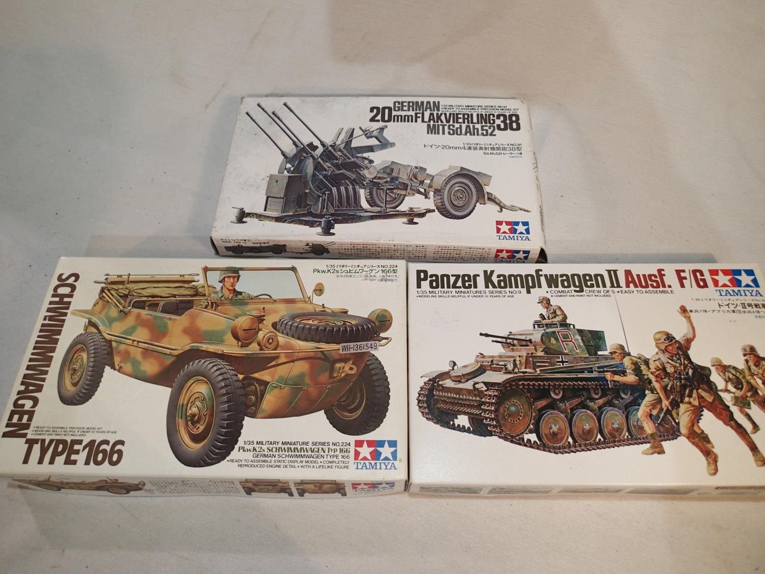 Three 1/35 scale military related kits by Tamiya, 20 mm Flakvierling, Schwimmwagen, Panzer