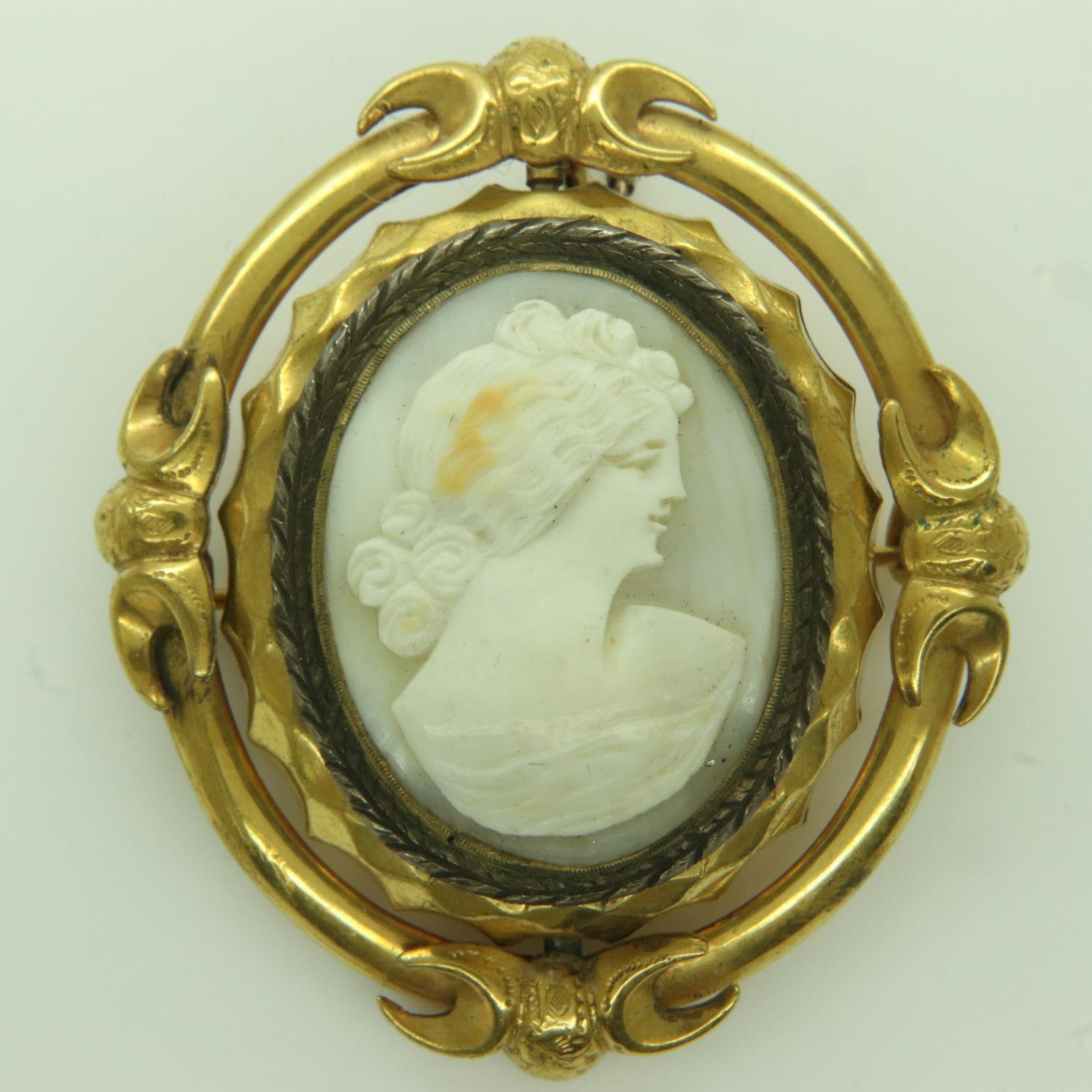A Victorian mourning brooch pendant, in an unmarked yellow metal frame, carved cameo front with