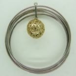 A contemporary Italian silver multi-sectional bangle with silver-gilt pierced ball charm, 25g. UK