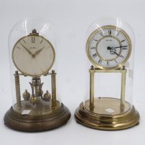 Benita brass anniversary clock with glass dome and a similar clock by Hermle, H: 30 cm, Not