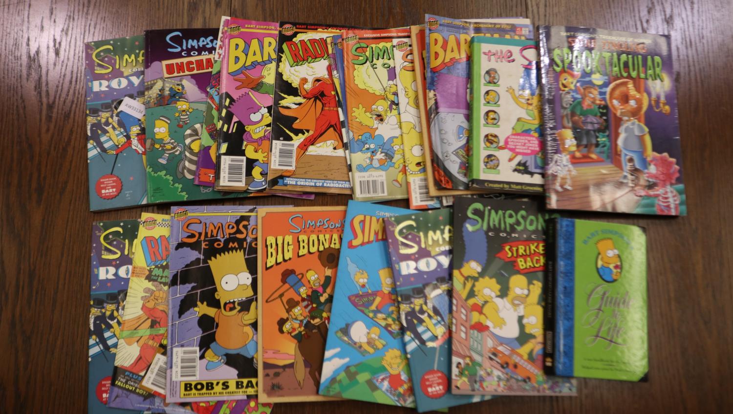 Shelf of Simpsons comics, books and graphic novels. UK P&P Group 3 (£30+VAT for the first lot and £