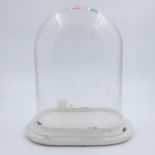 Large glass display dome on an oval ceramic base, L: 39 cm. Not available for in-house P&P
