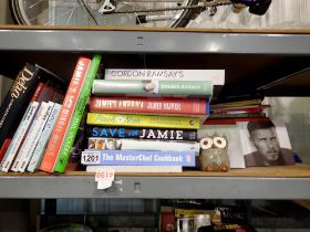 Shelf of cookery books including Jamie Oliver, and Take That/Gary Barlow CDs. Not available for in-