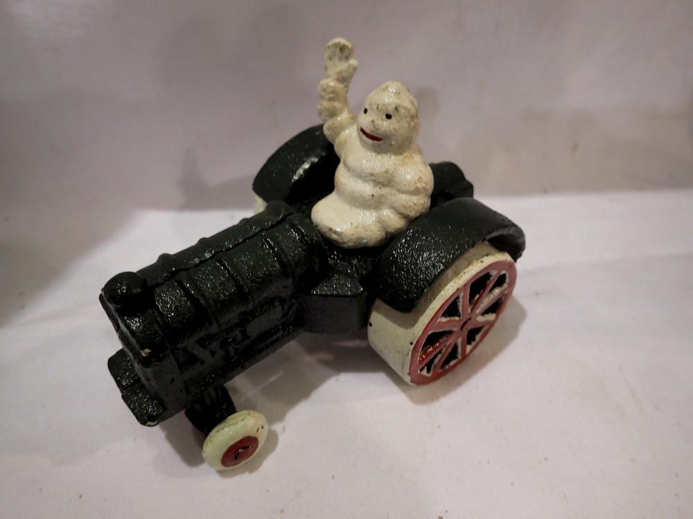 Cast iron Michellin Man on a tractor. H:80mm. UK P&P Group 1 (£16+VAT for the first lot and £2+VAT