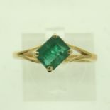 18ct gold emerald-set solitaire ring, the stone emerald-cut in a split setting, size O/P, 2.4g. UK