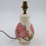 Cream ground Moorcroft table lamp base in the Pink Magnolia pattern, H: 28 cm, has hairline crack